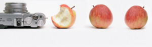 Das Bild zeigt eine Kamera mit drei Äpfeln